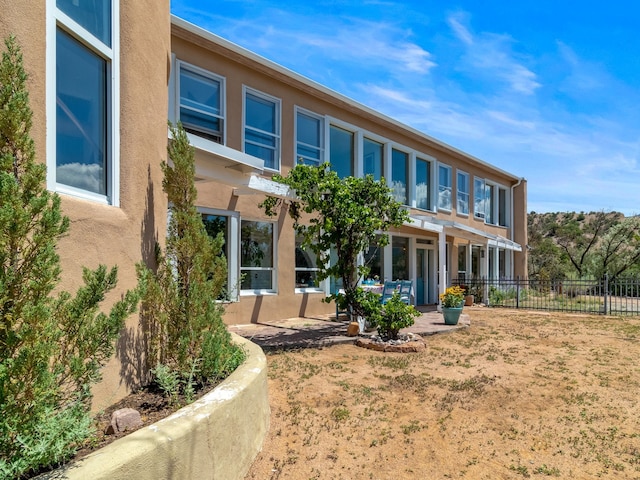 back of property featuring fence and stucco siding