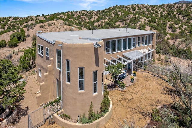 back of house with a patio area, fence, and stucco siding