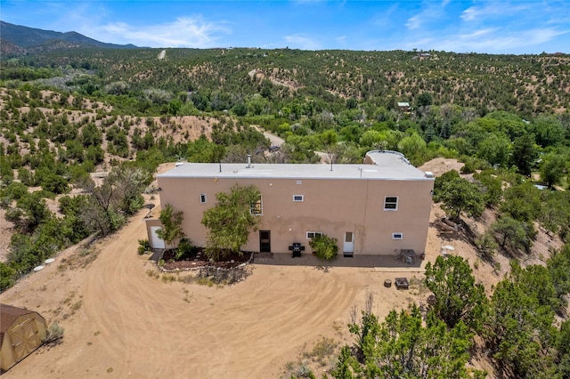 birds eye view of property with a mountain view and a wooded view