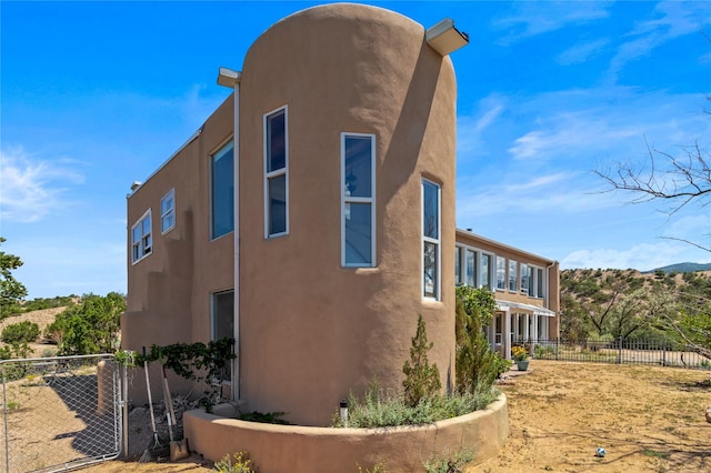 view of property exterior with fence and stucco siding