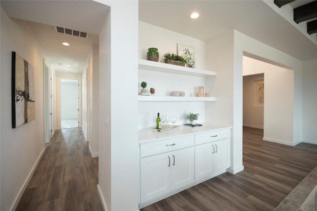 corridor with dark hardwood / wood-style flooring and built in features