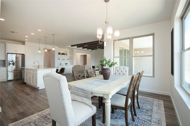 dining space with dark hardwood / wood-style flooring, sink, a notable chandelier, and plenty of natural light