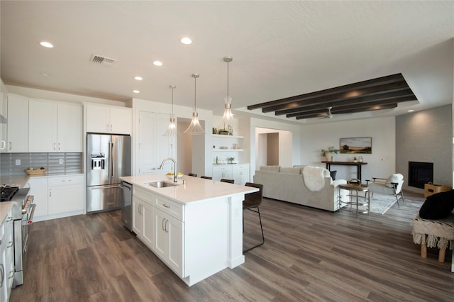 kitchen with sink, stainless steel appliances, an island with sink, and white cabinets