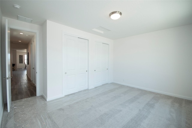 unfurnished bedroom featuring two closets