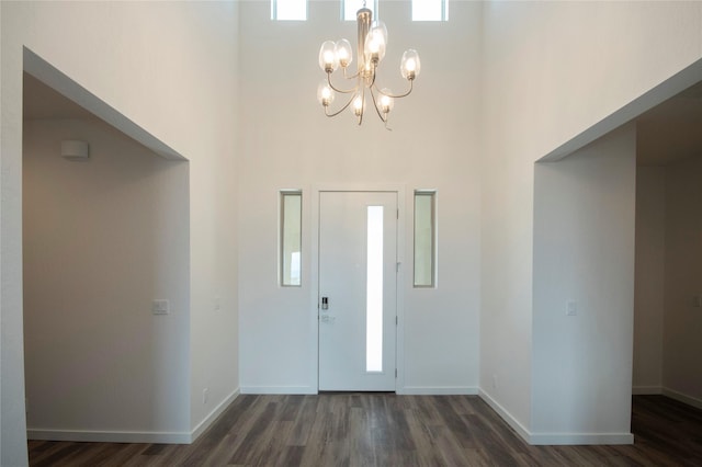 entryway featuring a high ceiling, dark wood-type flooring, and a notable chandelier