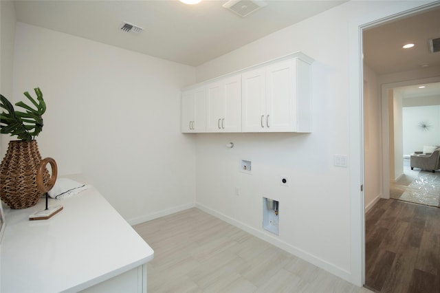 washroom with cabinets, light hardwood / wood-style flooring, hookup for a washing machine, electric dryer hookup, and hookup for a gas dryer