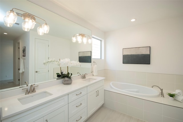 bathroom with vanity and tiled bath