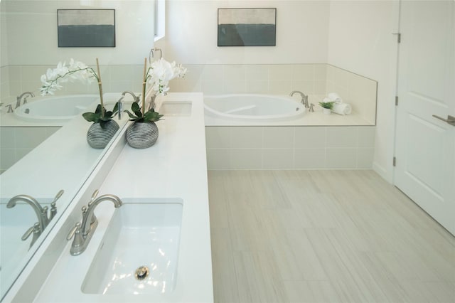 bathroom with vanity and tiled tub