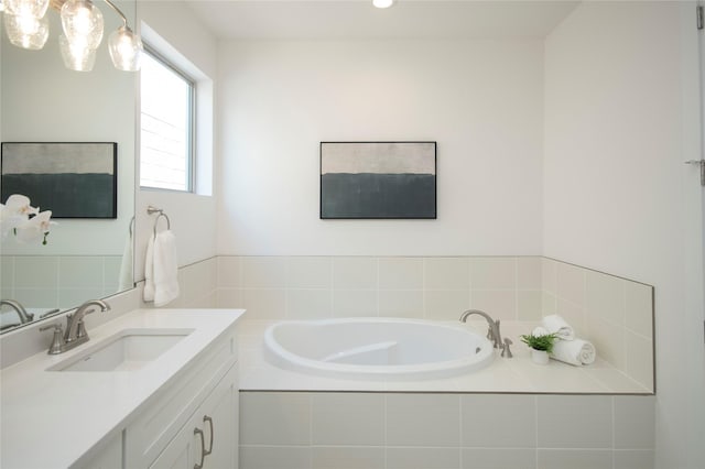 bathroom with vanity and tiled bath