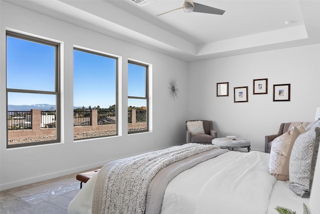 bedroom with carpet, ceiling fan, and a tray ceiling