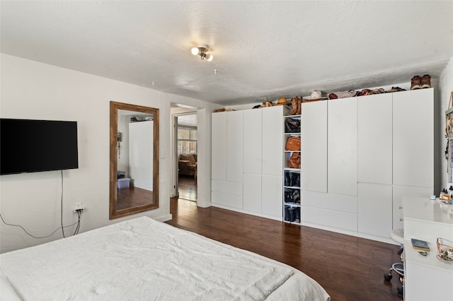 bedroom with a textured ceiling and wood finished floors