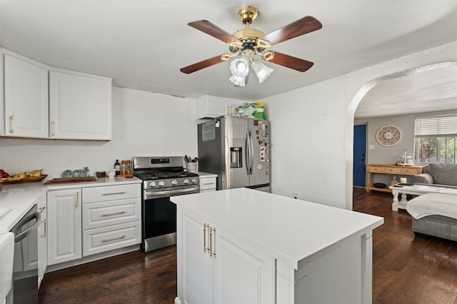 kitchen with white cabinets, appliances with stainless steel finishes, dark hardwood / wood-style floors, and a kitchen island