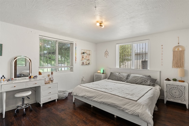 bedroom with a textured ceiling and dark hardwood / wood-style floors