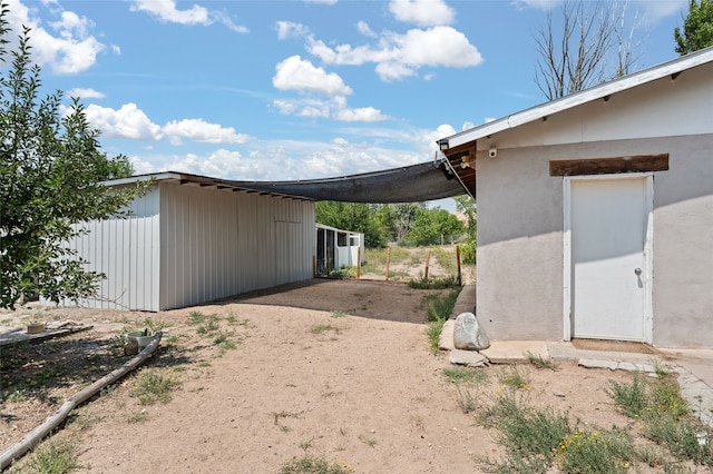 view of side of property featuring driveway and a carport