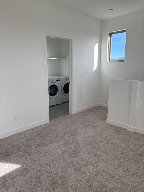 clothes washing area featuring independent washer and dryer and light colored carpet