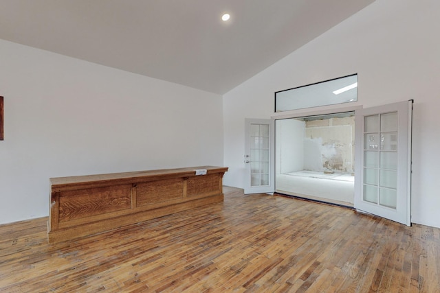 unfurnished room with recessed lighting, wood-type flooring, high vaulted ceiling, and french doors