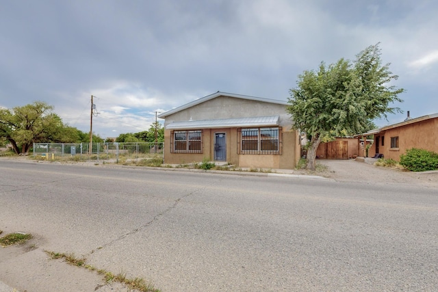 view of front facade featuring fence and stucco siding