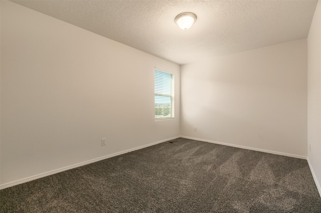 carpeted empty room with a textured ceiling