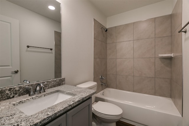 full bathroom featuring toilet, tiled shower / bath, and vanity