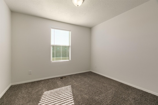 spare room featuring dark carpet