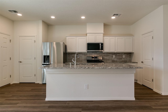 kitchen featuring white cabinets, a kitchen island with sink, light stone countertops, and stainless steel appliances