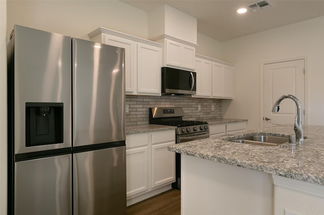 kitchen featuring light stone countertops, sink, white cabinetry, and appliances with stainless steel finishes