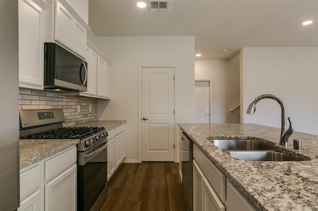 kitchen featuring white cabinetry, stainless steel appliances, light stone counters, and sink