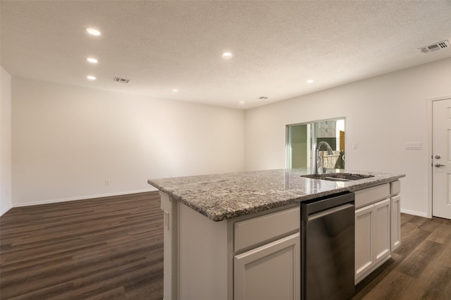 kitchen featuring white cabinetry, an island with sink, dark wood-type flooring, light stone counters, and sink