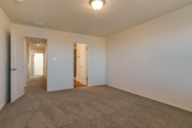 unfurnished bedroom featuring carpet floors, a closet, a spacious closet, and a textured ceiling