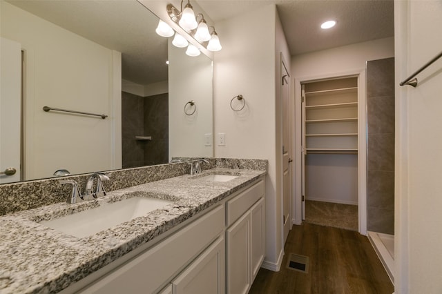 bathroom featuring a shower, hardwood / wood-style floors, and vanity