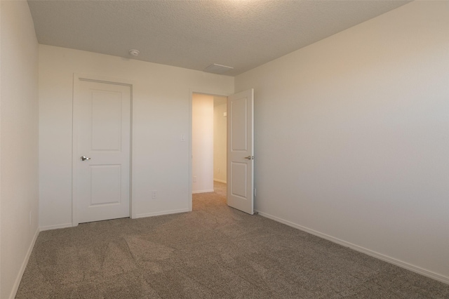 unfurnished bedroom with a textured ceiling and carpet