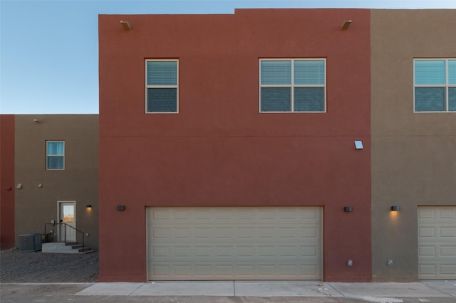 exterior space with a garage and central air condition unit