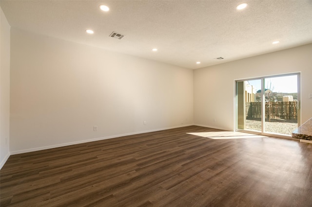 unfurnished room with a textured ceiling and dark hardwood / wood-style flooring