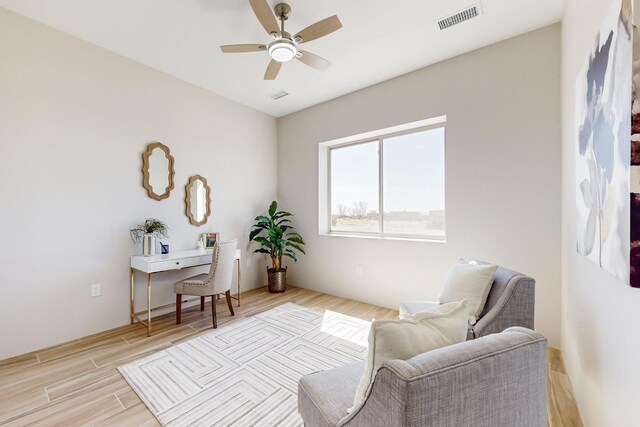 unfurnished bedroom featuring light wood-type flooring, ceiling fan, and a barn door