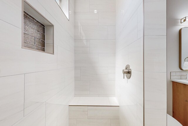 bathroom with a tile shower, vanity, toilet, and wood-type flooring