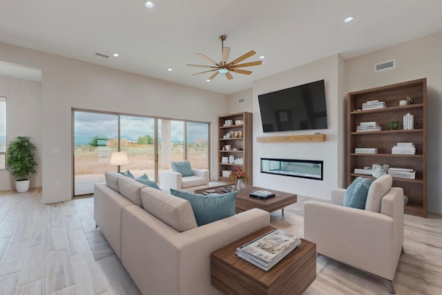 living room featuring light hardwood / wood-style flooring and ceiling fan