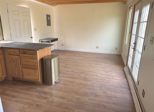 kitchen featuring kitchen peninsula, beam ceiling, electric panel, and hardwood / wood-style floors