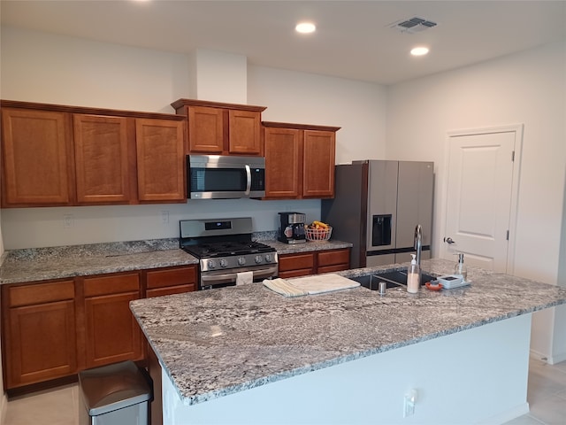 kitchen featuring sink, appliances with stainless steel finishes, a center island with sink, and light tile patterned floors