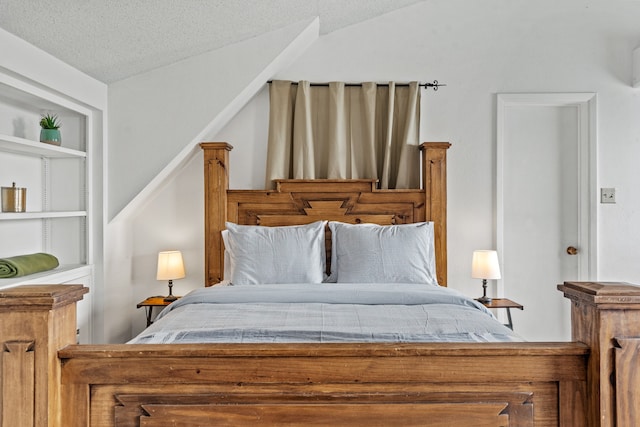 bedroom featuring a textured ceiling and vaulted ceiling