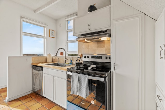 kitchen featuring light tile patterned floors, white cabinets, appliances with stainless steel finishes, decorative backsplash, and sink