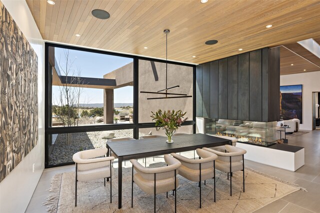 dining space featuring wood ceiling and a wall of windows