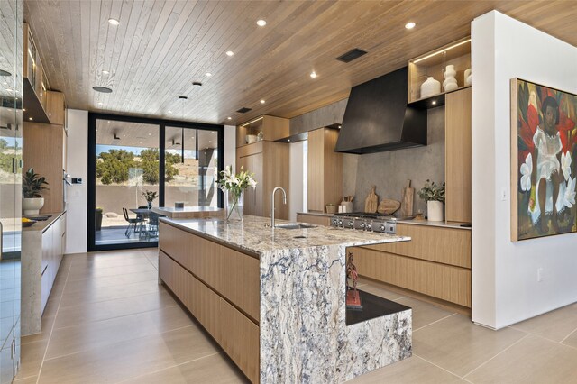 kitchen with sink, wooden ceiling, a large island with sink, and premium range hood