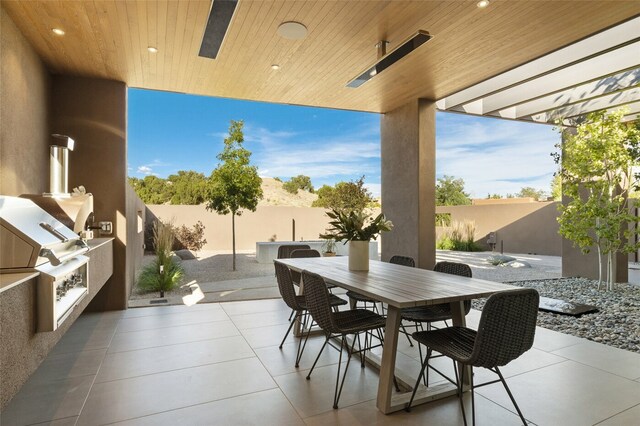 view of patio with area for grilling and a grill