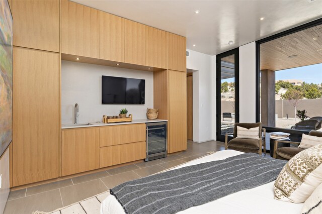 bedroom featuring wine cooler, indoor wet bar, access to outside, light tile patterned floors, and expansive windows