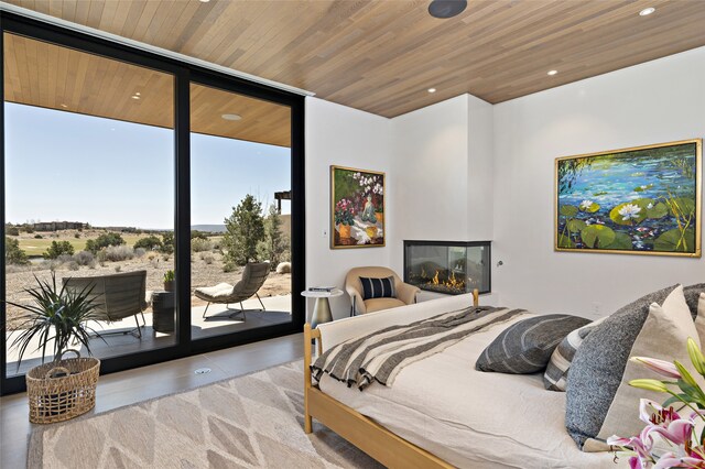 bedroom with wood ceiling, access to outside, and expansive windows