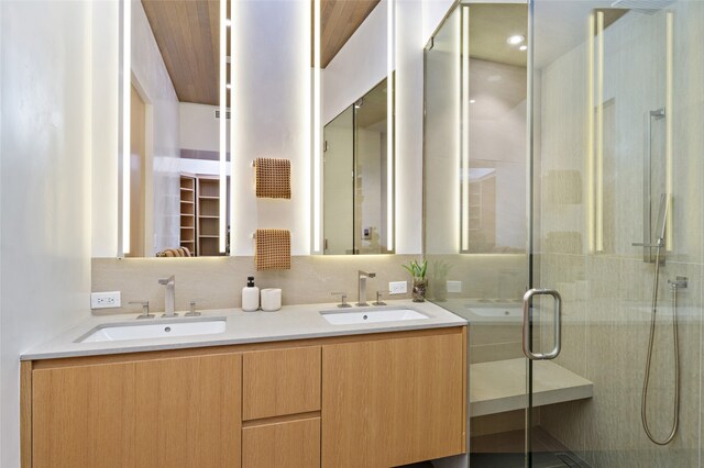 bathroom with vanity, an enclosed shower, and decorative backsplash