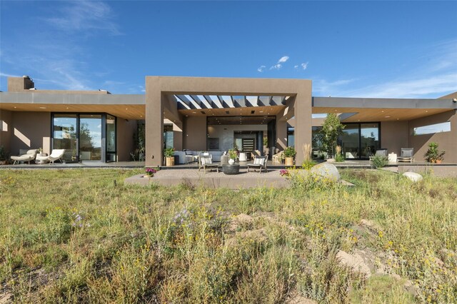 back of property featuring outdoor lounge area and a patio area