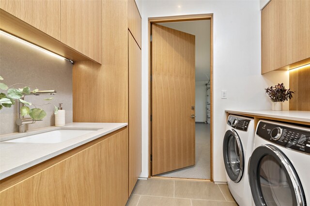 laundry area with sink, light tile patterned floors, and washer and dryer