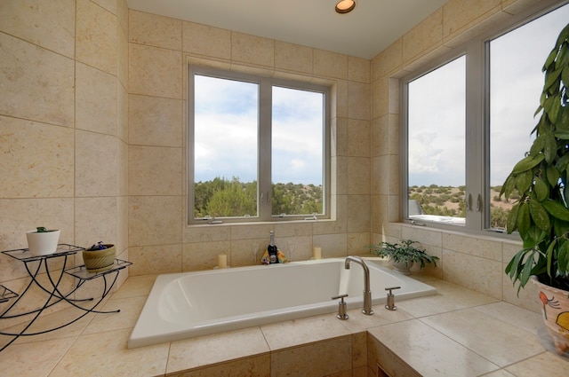 bathroom with tile walls, tiled tub, and a wealth of natural light