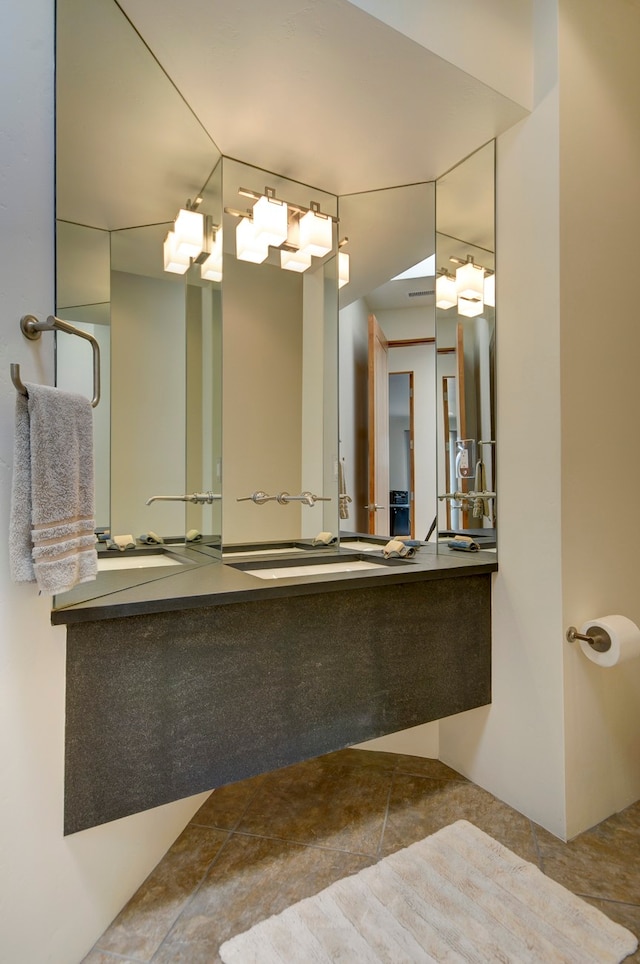 bathroom with dual bowl vanity and tile patterned flooring